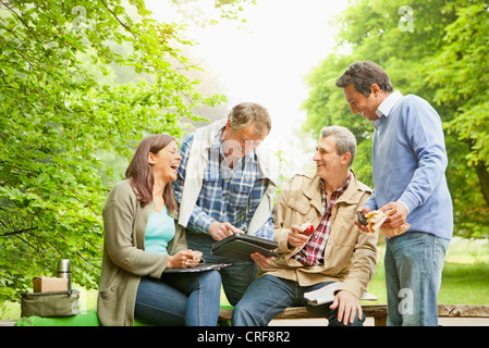 Tablet-Computer im Park mit Freunden Stockfoto