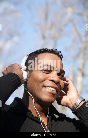Porträt von glücklicher junger Mann Musikhören mit Kopfhörer Stockfoto