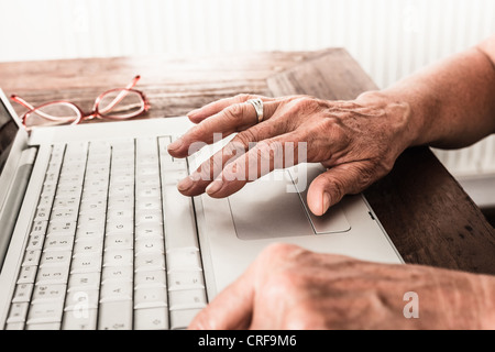 Schließen Sie oben von älteren mans Hände auf Laptop Stockfoto