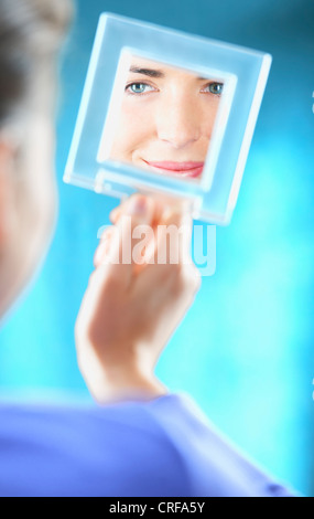 Frau, die sich selbst im Spiegel zu prüfen Stockfoto