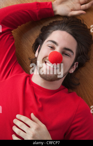Porträt eines fröhlichen jungen Mannes tragen rote Clownsnase Stockfoto