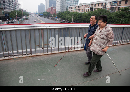 Wenigen blinden gehen Arm in Arm zusammen in Fuchengmen, Peking, China. Stockfoto