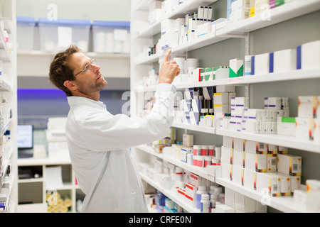 Apotheker Medikamente auf Regal durchsuchen Stockfoto