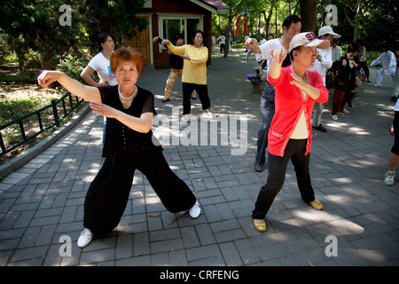 Menschen nehmen ihre Morgen Tai Chi Chuan trainieren Sie im Zizhuyuan Park (lila Bambuspark) in Peking, China. Stockfoto