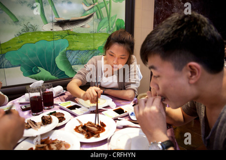 Junge Kunden in dem großen Speisesaal. Quanjude Roast Duck Restaurant in Wangfujing, Beijing. Stockfoto