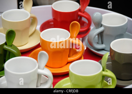 Farbige Tassen und Saucen mit passenden integrierten Teelöffel Stockfoto