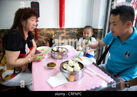 Eine Familie hat chinesische Knödel zum Frühstück in einem kleinen Restaurant in Xuanwu District, einem Gebiet südlich von Tiananmen, Beijing. Stockfoto