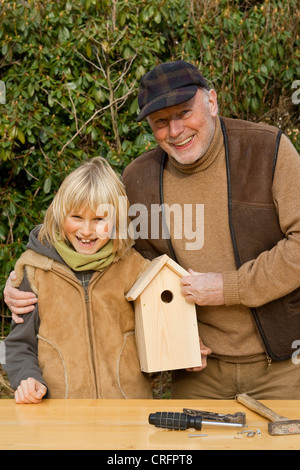 nisten Sie Kastenbauweise, Opa und Enkel präsentiert einen Eigenbau aus Holz Nistkasten, Deutschland Stockfoto