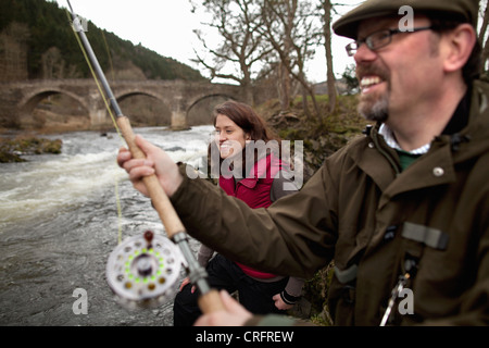 Paar Lachsfischen im Fluss Stockfoto