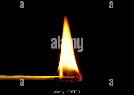 Brennendes Streichholz vor schwarzem Hintergrund Stockfoto