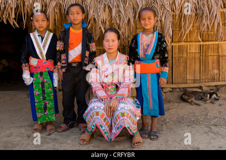 Hmong-Familie in traditionial Kleidung vor ihrer Hütte, Laos Stockfoto