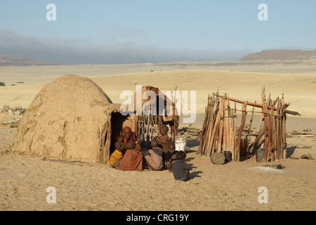 traditionelle Dorf Purros, Himba-Frau mit Kindern vor einer Hütte, Namibia, Purros Stockfoto