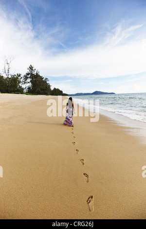 Frau macht Fußabdrücke am Sandstrand Stockfoto