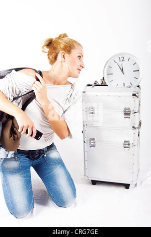 Junge, blonde Frau unter Zeitdruck, Blick auf eine Uhr Stockfoto