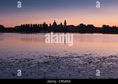 Skyline der Stadt bei Sonnenuntergang im See widerspiegelt. Stockfoto