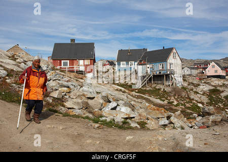 ältere Inuit-Frau vor Holzhäuser, Grönland, Ammassalik, Ostgrönland, Tiniteqilaq Stockfoto