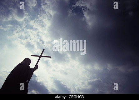 DAS KREUZ HALTEND Stockfoto