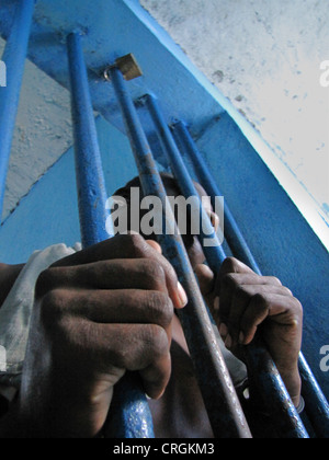 Häftling hinter Gittern eines Fensters in heruntergekommenen predetention Zelle (Garde Vue) bei Polizei, Kommissariat von J R Mie, Haiti, Grande Anse, Jeremie Stockfoto