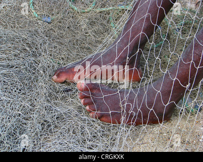 Mann Nähte, Reparatur von alten Fishernet, mit den Füßen, Haiti, Grande Anse, Dame Marie festhalten Stockfoto