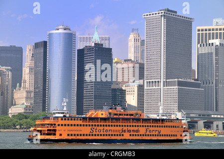 Die Staten Island Ferry übergibt Battery Park als New York Wolkenkratzer Tower im Hintergrund Stockfoto