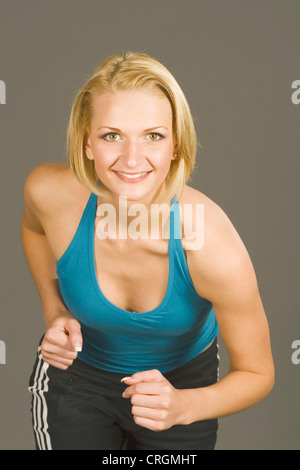junge sportliche, blonde Frau läuft Stockfoto