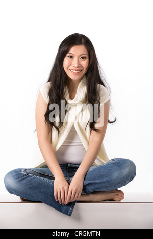 Gerne Asiatin in Freizeitkleidung. Isoliert auf weißem Hintergrund. Stockfoto