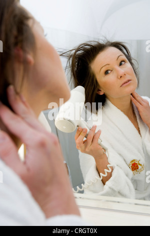 junge Frau im Bad trocknen Sie ihr Haar Stockfoto