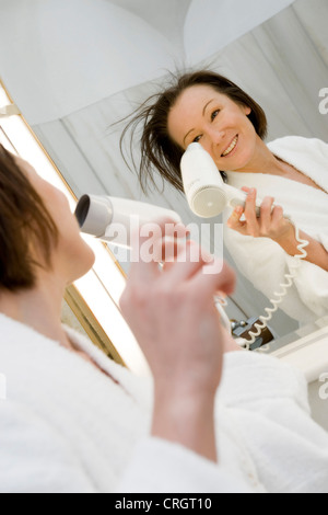 junge Frau im Bad trocknen Sie ihr Haar Stockfoto