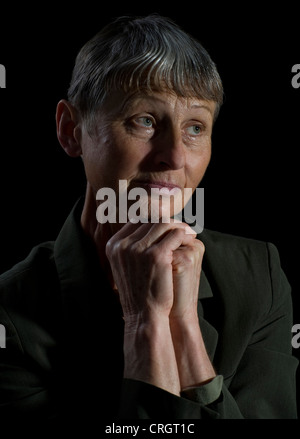 Porträt einer nachdenklich ältere Frau mit gefalteten Händen Stockfoto