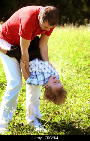 Vater spielt mit seinem Sohn auf einer Wiese im Sommer Stockfoto