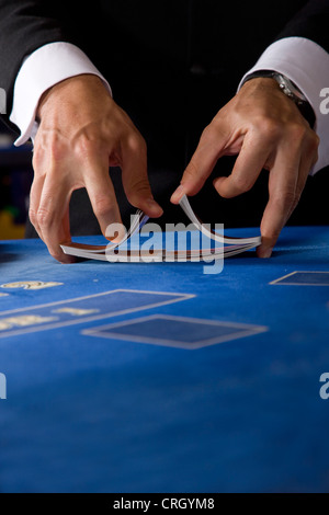 zwei Hände, die ein Deck von Karten in einem Casino zu mischen Stockfoto