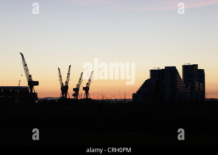 Sonnenuntergang über den BAE Systems Shipyard Kräne in Govan und Glasgow Harbour Apartments, Glasgow, Schottland, UK Stockfoto