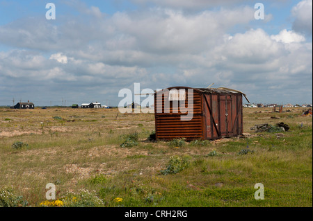 Fischerhütte Lagerung am Strand bei Dungeness, Kent, UK mit Jarmans Haus im Hintergrund (auf der linken Seite der Hütte) Stockfoto