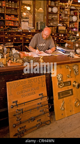 Mann am Schalter des nostalgischen Interieurs gestaltet von alten Ironmongers Shop auf Swan Street Warwick England Stockfoto