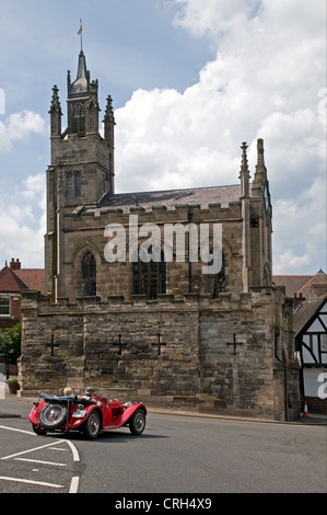 Kapelle von St. Peter auf alten mittelalterlichen Stadtmauer an der East Gate Warwick in England mit roten Sportwagen der 1930er Jahre MG Stockfoto