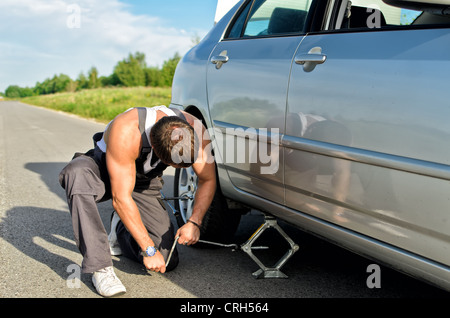 Mechaniker, die ein Auto mit Jack-Schraube anheben Stockfoto