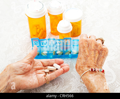 Closeup Blick auf eine 80 Jahre alte senior Frauenhand, wie sie ihre verschreibungspflichtige Medizin sortiert. Stockfoto
