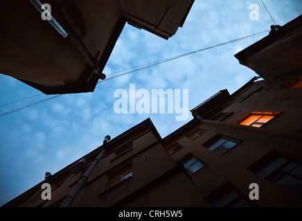 Nachschlagen in der Altstadt in der Nacht. Dunkle Wände mit beleuchteten Fenster. St. Petersburg, Russland Stockfoto