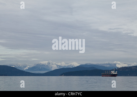 Eine Frachtschiff wartet im Ärmelkanal Küste von Vancouver an einem bewölkten Wintertag. Stockfoto