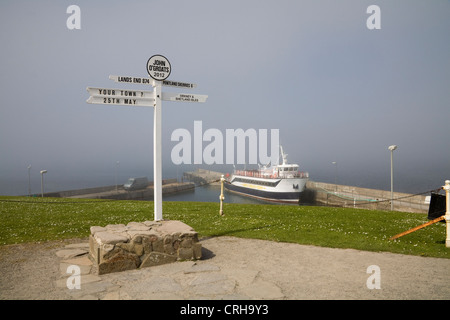 John O' Groats Caithness Schottland Mai Wegweiser vor Pentland Venture Personenfähre auf nebligen Tag Stockfoto