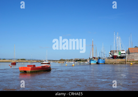 Rote und blaue geschält Boote vertäut in der Mündung und am Kai bei Ebbe, Topsham, Devon, England, UK Stockfoto