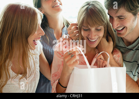 Junge Frau Eröffnung Geschenk von Freunden Stockfoto