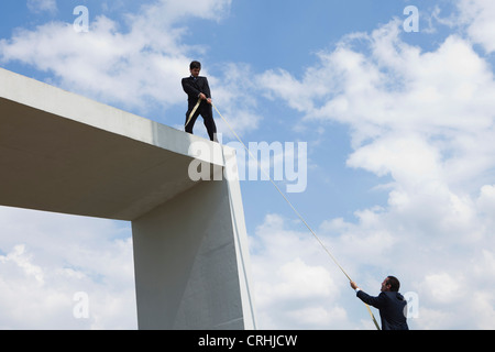 Geschäftsmann bietet helfende Hand für Kollegen Stockfoto