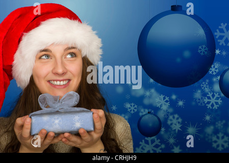 Junge Frau in Weihnachtsmütze hält Weihnachten Geschenk, Portrait Stockfoto