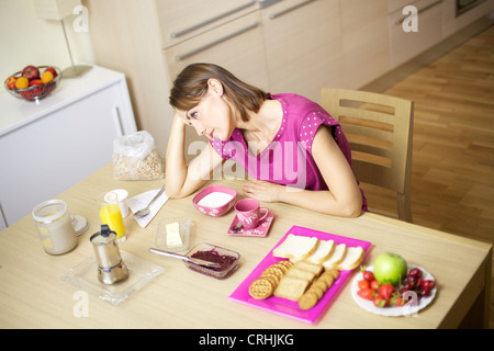 trauriges weibliches Modell denken unglücklich vor sehr reichhaltiges Frühstück Stockfoto
