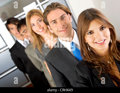 junge Geschäftsleute, die in einer Reihe mit einer Frau an der Spitze, Lächeln Stockfoto