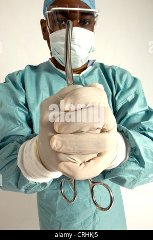 Ein Chirurg, ein paar Zangen in den gefalteten Händen hält. Stockfoto