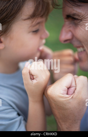 Vater und Sohn mit geballten Fäusten dösen Stockfoto