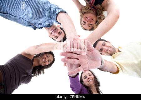 Glückliche Gruppe von Freunden mit ihren Händen zusammen in der Mitte Stockfoto