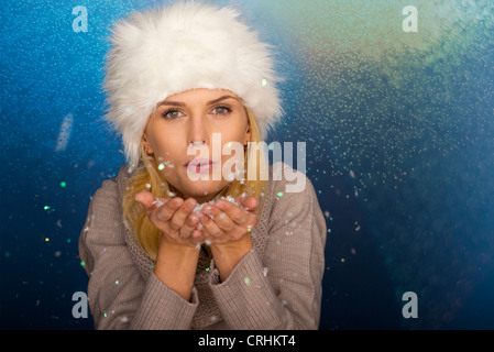 Frau bläst Handvoll Konfetti, Porträt Stockfoto